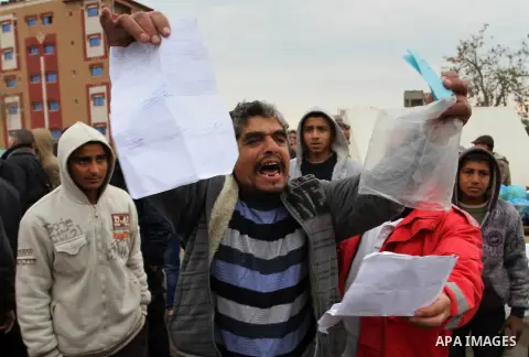 A Palestinian man showing his documents reacts as he takes part with others in a protest calling for reconstruction of their houses that witnesses said were destroyed by Israeli shelling during a 50-day war last summer,...