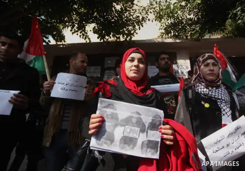 Palestinian youths take part during a protest against the murders of three Muslim students in Carolina, outside the Keir American foundation in Gaza city on February 16, 2015. Craig Stephen Hicks, 46, has been charged wi...