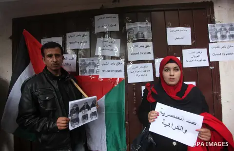 Palestinian youths take part during a protest against the murders of three Muslim students in Carolina, outside the Keir American foundation in Gaza city on February 16, 2015. Craig Stephen Hicks, 46, has been charged wi...