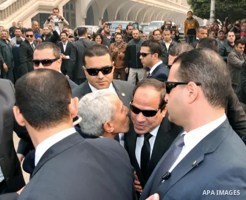 A handout photo made available by the Egyptian Presidency shows Egyptian President Abdel Fattah al-Sisi (C), is received at St. Mark's Cathedral in Cairo, to offer condolences after the killing of Egyptian Christians in...