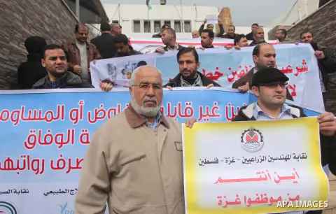 Palestinian employees of former Palestinian government take part a protest demanding their salaries to be paid, in front of the Legislative Council in Gaza city on February 18, 2015. Some 40,000 civil servants employed b...
