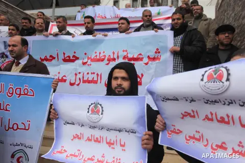 Palestinian employees of former Palestinian government take part a protest demanding their salaries to be paid, in front of the Legislative Council in Gaza city on February 18, 2015. Some 40,000 civil servants employed b...