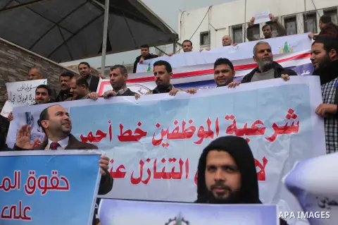 Palestinian employees of former Palestinian government take part a protest demanding their salaries to be paid, in front of the Legislative Council in Gaza city on February 18, 2015. Some 40,000 civil servants employed b...