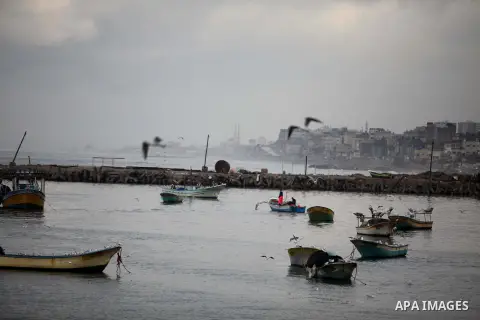 Palestinian fishermen ride their boat during a rainy day at the seaport near the coast of Gaza city, February 18, 2015. Photo by Ashraf Amra