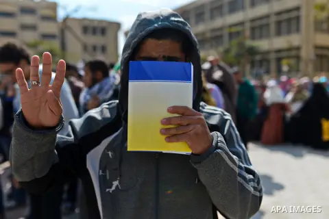 An Egyptian student who support ousted President Mohamed Morsi and the Muslim Brotherhood, flashes Rabaa sign during protest against the military rule, in Cairo University on February 18, 2015. Due to the escalation of s...