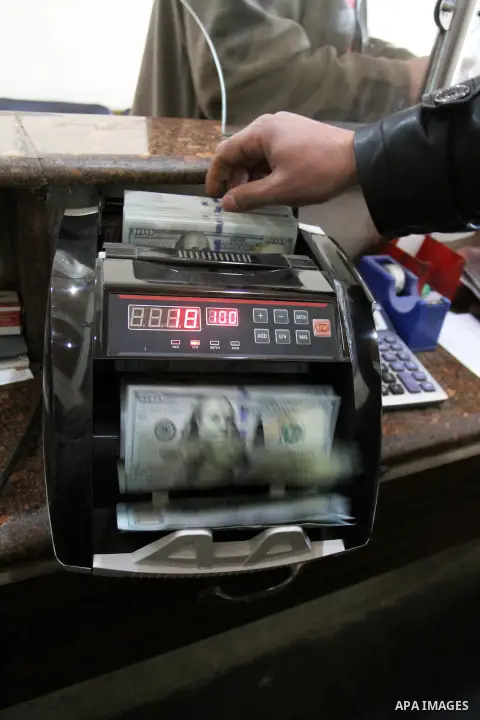 A Palestinian money changer uses a machine to count money at an currency exchange office, in Rafah in the southern Gaza Strip, February 19, 2015. The European Commission announced on Tuesday February 17, the EU allocated...