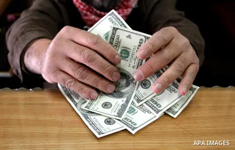 A Palestinian money changer counts money at an currency exchange office, in Rafah in the southern Gaza Strip, February 19, 2015. The European Commission announced on Tuesday February 17, the EU allocated 212 million euro...