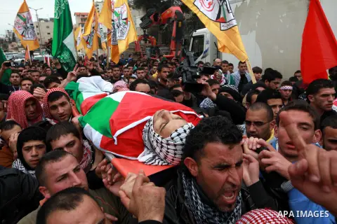 Palestinian mourners carry the body of 19-year old Palestinian Jihad al-Jaafari, who was shot dead on the roof of his house after Israeli soldiers entered the Dheishe refugee camp, near the West Bank city of Bethlehem be...