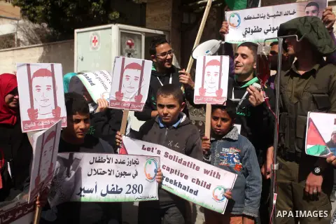 Palestinians hold banners and portraits of Khaled al-Sheikh, a 14-years-old Palestinian boy jailed in an Israeli prison, during a rally calling for his release in Gaza City February 25, 2015. According to the al-Sheikh f...