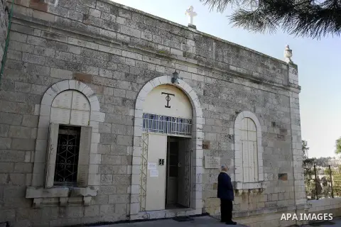 A Greek Orthodox priest stands outside a seminary in Jerusalem, Thursday Feb. 26, 2015. The Greek Orthodox seminary was damaged in fire and anti-Christian slogans were written in Hebrew, in what Israeli police said the s...