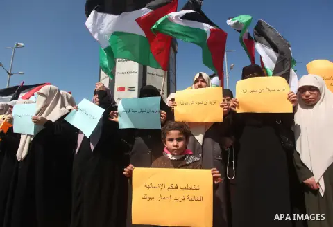 Palestinian women take part in a protest demanding for the opening of a waterway, reconstruction of houses, and to break the siege at the Gaza seaport on March 05, 2015. Photo by Ashraf Amra