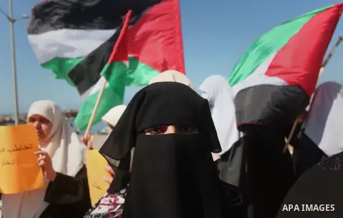 Palestinian women take part in a protest demanding for the opening of a waterway, reconstruction of houses, and to break the siege at the Gaza seaport on March 05, 2015. Photo by Ashraf Amra