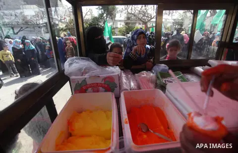 A Palestinian man sells Ice-cream during a rally of Hamas supporters in front of the headquarters of the United Nations Relief and Works Agency (UNRWA) on the occasion of International Women's Day in Gaza City on March 8...