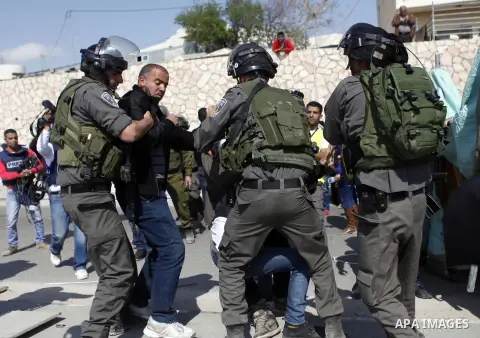 Israeli soldiers detain a Palestinian protesters during a demonstration against the confiscation of the land by Israel for Jewish settlements near the West Bank town of Abu Dis near Bethlehem on March 17, 2015. Photo by...