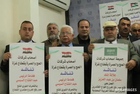 Palestinian Owners the association pilgrimage agencies and travel companies hold banners during a press conference, in Gaza city on March 18, 2015. Some 50,000 Gazans typically travel for the umrah each year, and travele...