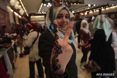 A Palestinian woman shows her hand painted with traditional henna tatoos during the Palestinian heritage entitled "products of our women", in Gaza City, on March 18, 2015. Photo by Ashraf Amra