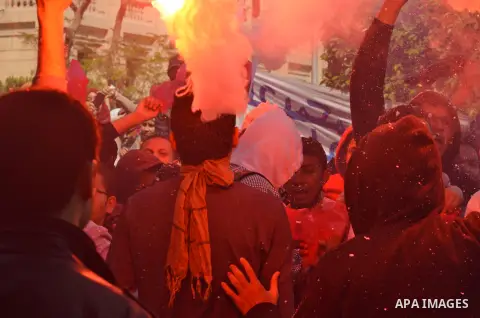 An Egyptian students who support ousted President Mohamed Morsi and the Muslim Brotherhood, lights a flare during protest against the military rule, in Cairo University on March 18, 2015. Photo by Amr Sayed