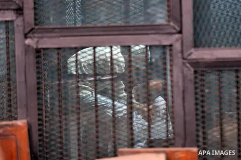 Defendants of the Marriott terror cell case stand in cages in a court, Cairo on March 19, 2015. The court adjourned the retrial of two Al-Jazeera's journalists, including Fahmy, who were freed on bail after more than 400...