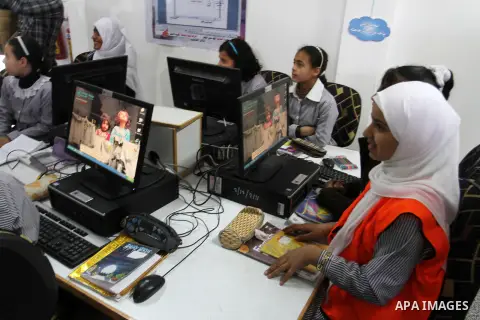 Palestinian schoolgirls sit inside their classroom during the opening ceremony of Khuza'a school, which witnesses said was destroyed by Israeli forces during the most recent conflict between Israel and Hamas, in Khuza'a...