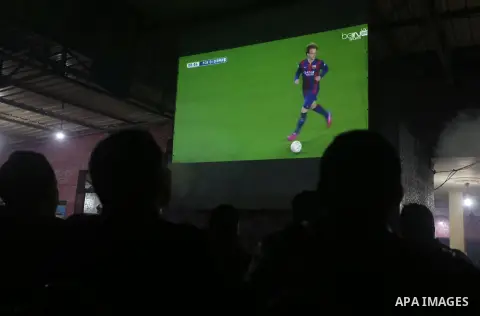 Palestinian youths watch a soccer match for Barcelona's team against Real Madrid team during the end of their Spanish first division "Clasico" soccer match at cafe, in Gaza city on March 22, 2015. FC Barcelona won 2-1 ag...