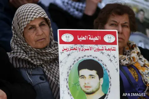Palestinians take part in a protest demanding the release of their relatives prisoners held in Israeli jails, in front of Red cross office, in the West bank city of Ramallah, on March 24, 2015. Photo by Shadi Hatem