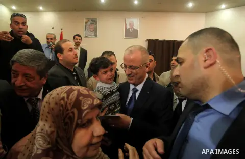 Palestinian prime minister Rami Hamdallah visits an orphanage during his visit to the Gaza Strip, in Gaza city on March 26, 2015. Hamdallah urged rival factions to set aside their differences, even as protesters gave him...