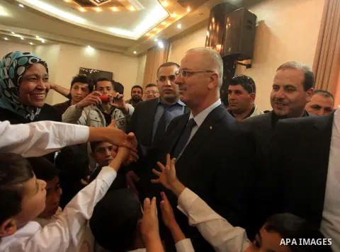Palestinian prime minister Rami Hamdallah visits an orphanage during his visit to the Gaza Strip, in Gaza city on March 26, 2015. Hamdallah urged rival factions to set aside their differences, even as protesters gave him...