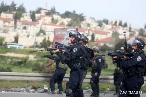 A member of Israeli security forces aims at Palestinian protesters during clashes following a demonstration against the Israeli settlement of Beit El, in the Jalazon refugee camp near the West Bank city of Ramallah on Ma...