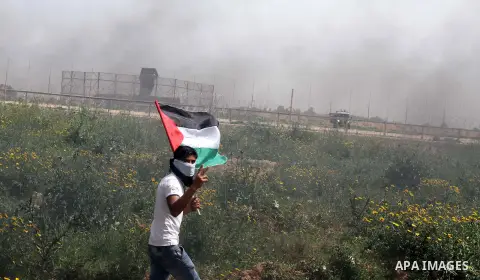 A Palestinian man holds a national flag during a rally marking Land day in Khan Younis in the southern Gaza strip, on March 29, 2015. The annual demonstrations mark the deaths of six Arab Israeli protesters at the hands...