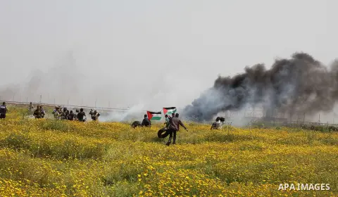 A Palestinian man holds a national flag during a rally marking Land day in Khan Younis in the southern Gaza strip, on March 29, 2015. The annual demonstrations mark the deaths of six Arab Israeli protesters at the hands...