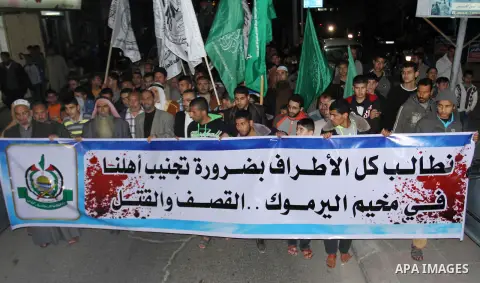 Palestinians hold banners during a protest to show solidarity with Palestinian refugees Syria's main refugee camp Yarmouk in Khan Younis in southern Gaza Strip on April 04, 2015. Photo by Ramadan El-Agha