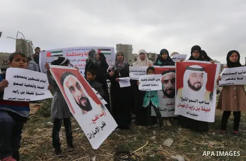 Relatives of Palestinian orphans hold banners during a protest against stop the payment of orphans aid in front of the rubbles of houses were destroyed during a seven-week Israeli offensive, in the east of Gaza City, on...