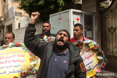 Palestinians take part in a symbolic funeral for the former Palestinian prisoner Jaafar Awad, who was recently released from Israeli jail, in front of Red cross office in Gaza city on April 11, 2015. Israeli troops shot...