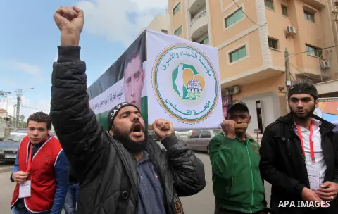 Palestinians take part in a symbolic funeral for the former Palestinian prisoner Jaafar Awad, who was recently released from Israeli jail, in front of Red cross office in Gaza city on April 11, 2015. Israeli troops shot...