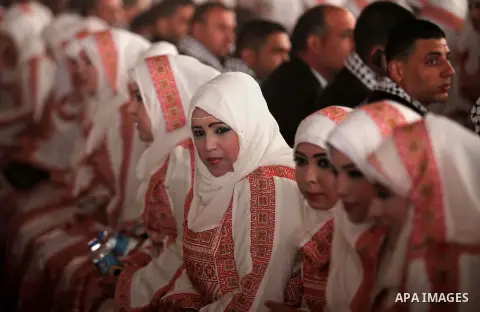 Palestinian brides take part in a mass wedding ceremony in Gaza City, on April 11, 2015. Nearly 200 Palestinian couples were married in a ceremony funded by an Emirati governmental organisation. Photo by Ashraf Amra