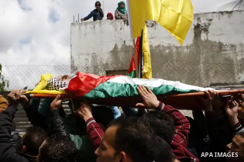 Mourners carry the body of 27-year-old Palestinian Mohammed Jasser Karakra, during his funeral in the Sinjil village, in the occupied West Bank city of Ramallah, on April 13, 2015. Karakra stabbed two Israeli soldiers in...