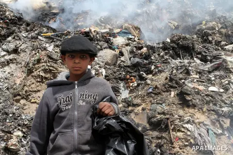 A Palestinian boy carries recyclables collected from the garbage near the border with Israel, east of Rafah town, in the southern Gaza Strip, April 16, 2015. Workers collect the household recyclables, metals and plastic...