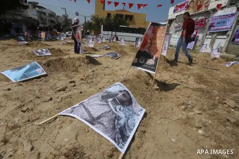 Supporters of the Popular Front for the Liberation of Palestine put the pictures of the prisoners on the symbolism graves during a protest, in Gaza city, on April 18, 2015. Photo by Mohammed Asad