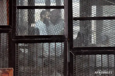 Members of Ansar Bayt al-Maqdis stand behind bars at a courtroom, during their trial in Cairo on April 18, 2015. 213 defendant members of Ansar al-Bayt al-Maqdis, including 140 defendants locked up, for committing a crim...
