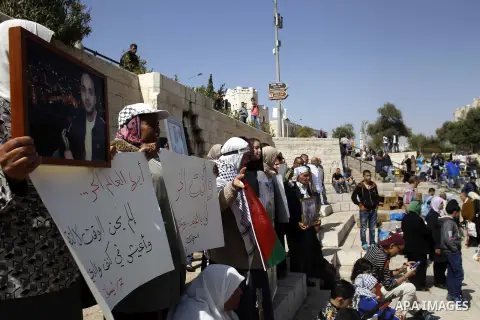 Palestinians hold banners during a rally marking Palestinian Prisoner Day in front of Damascus gate at the Al-Aqsa mosque compound, in Jerusalem's old city, on April 18, 2015. The current number of Palestinians held in I...