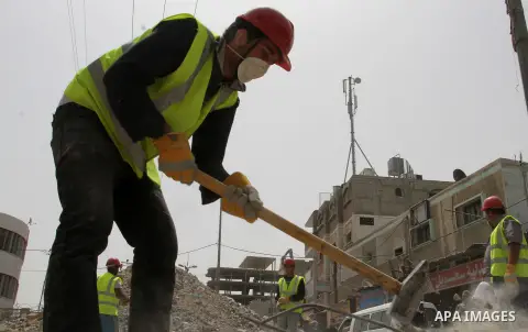 Palestinian workers re-build the commercial center which was destroyed by Israeli shelling during a 50- day-war in 2014 summer, in Rafah in the southern Gaza Strip April 20, 2015. Funded by the United Nations Development...