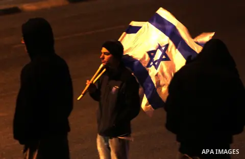 Israeli settlers hold flages during a rally to mark Israel's Independence Day, in the east Jerusalem neighborhood of Beit Hanina, April 21, 2015. Photo by Saeb Awad