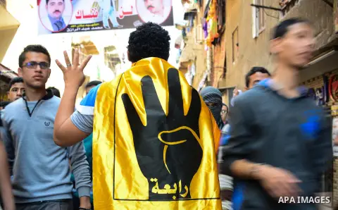 Egyptian supporters of the Muslim Brotherhood and ousted President Mohamed Morsi, flash Rabaa sign during a demonstration against the military and interior ministry, in al-Matariya district, near Cairo on April 24, 2015....