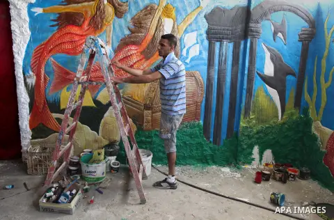 Palestinian artist Jihad Al-Ghoul, 23, works at his house in Bureij refugee camp in the center Gaza Strip, on April 25, 2015. Al-Ghoul said that he lost his leg in an Israeli attacked on Bureij refugee camp in 2008. Phot...