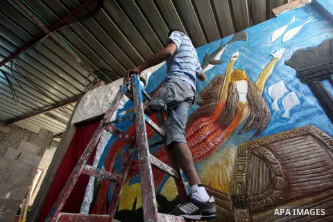 Palestinian artist Jihad Al-Ghoul, 23, works at his house in Bureij refugee camp in the center Gaza Strip, on April 25, 2015. Al-Ghoul said that he lost his leg in an Israeli attacked on Bureij refugee camp in 2008. Phot...