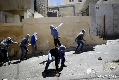 A masked Palestinian youths throw stones towards Israeli security forces during clashes on April 25, 2015 in Al-Tur neighbourhood of annexed Arab east Jerusalem, after Israeli police shot dead a knife-wielding Palestinia...
