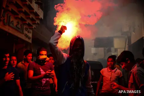 Egyptian supporters of Muslim Brotherhood and ousted president Mohammed Morsi, lights flares during a protest against military rule in al-Matariya district, near Cairo on May 1, 2015. Photo by Amr Sayed
