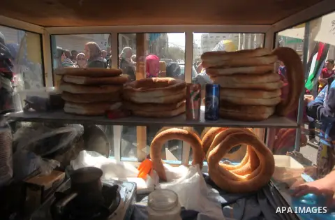 A Palestinian vendor sells cookies during a protest demanding release the prisoners in Israeli jails, in front of Red cross office, in Gaza city, on May 4, 2015. Photo by Ashraf Amra