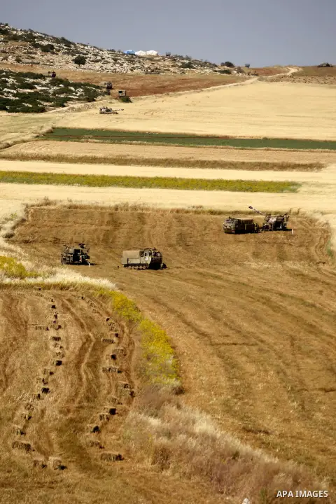 Israeli soldiers sit next to their vehicles during a military training in the Jordan valley, near the West Bank town of Tubas, on May 6, 2015. Besieged Palestinian communities in the occupied West Bank's Jordan Valley ha...