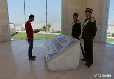 Palestinian man prays on the grave of late Palestinian leader Yasser Arafat in the West Bank city of Ramallah on May 07, 2015. Photo by Shadi Hatem